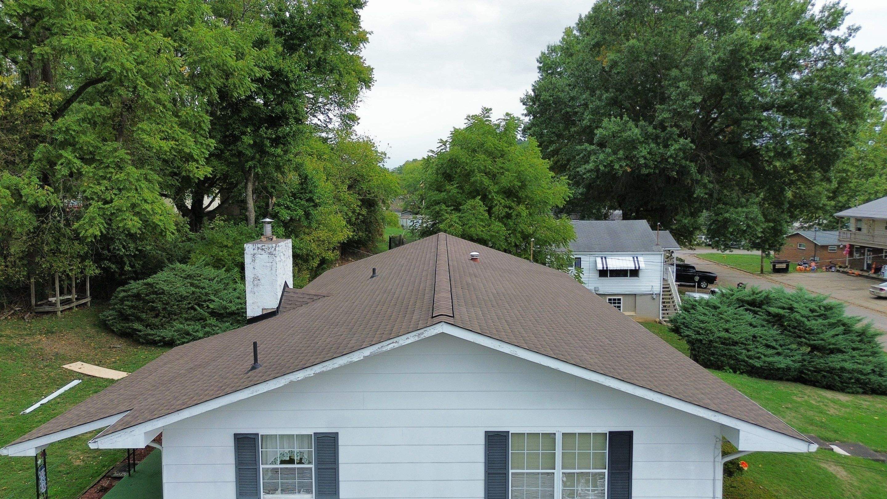 Brown shingles on a white home with white brick chimney